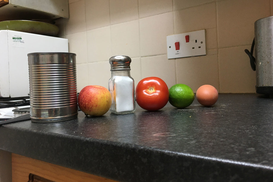 Image of a can, apple, salt, tomato, lime and egg, which spells out castle