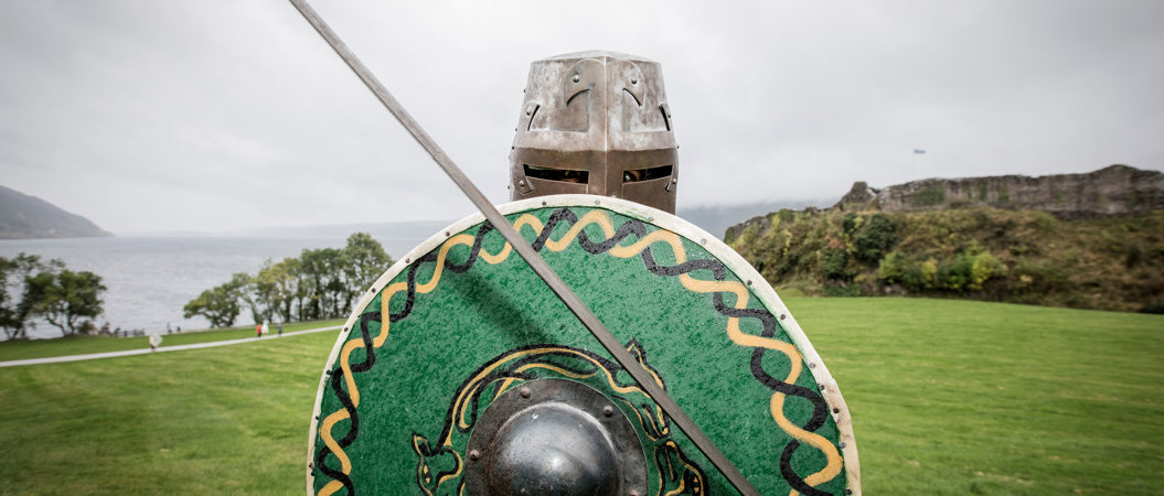 Reenactor holding a shield and sword and wearing a helmet
