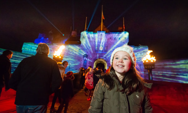 A girl and other people around her on the esplanade at Edinburgh Castle for the Castle of Light event
