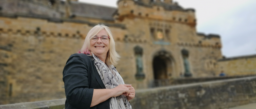 Susan Morrison standing outside Edinburgh Castle, smiling