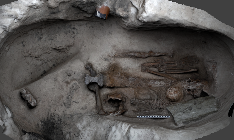 digital rendering from above showing a skeleton in a crouched position with grave goods