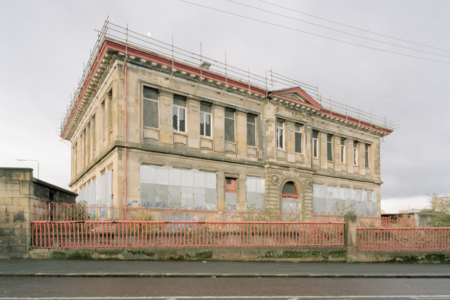 A once grand school building, now with boarded up windows