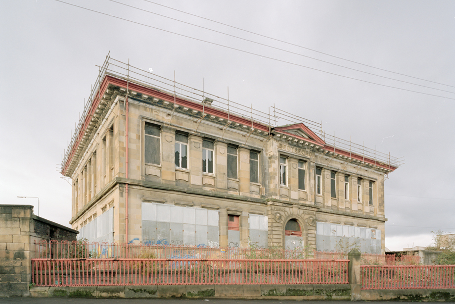 A once grand school building, now with boarded up windows