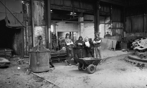 Four people standing in an industrial workshop