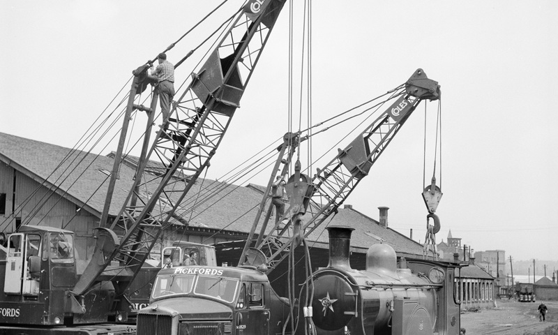 People and cranes moving a train