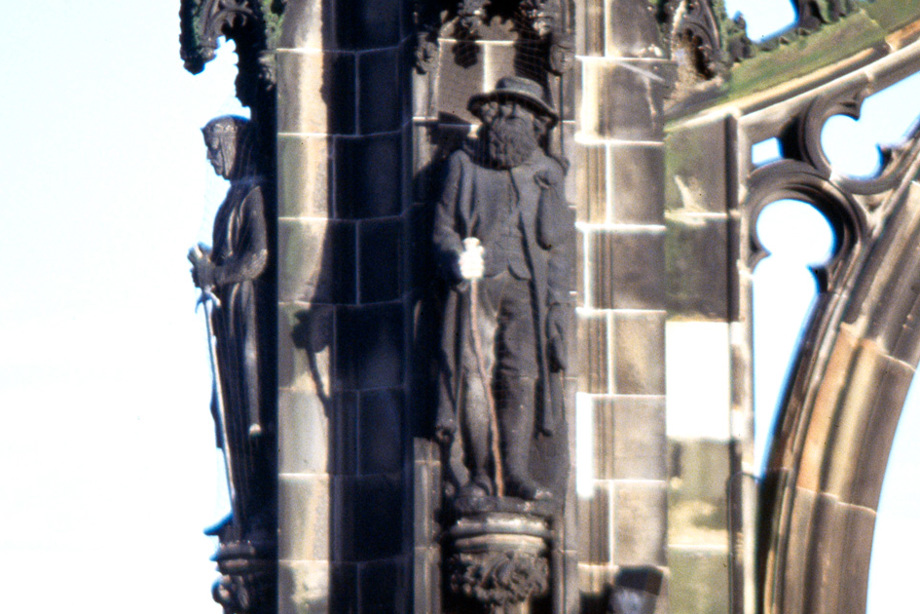Statues on the side of a monument of two men, one wearing armour and another with a long beard and a walking stick