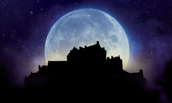 Silhouette of Edinburgh Castle with moon in the background