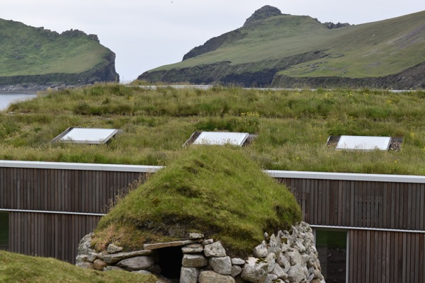 Overlooking the bay in St Kilda - a cleit with machair, overlooking the green roof of the modern research station, with the ridge behind.