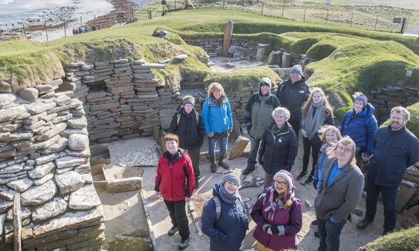 People in a replica house at Skara Brae