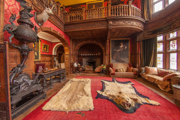 This is the main hall of Kinloch Castle, wood panelled throughout. Stag's heads are lined up on the walls and animal skins lie on the floor.