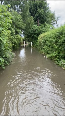 A lane is flooded with sewage water as it seeps out the burn covering the path.
