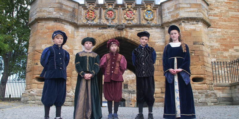 Junior tour guides in costume standing outside Linlithgow Palace