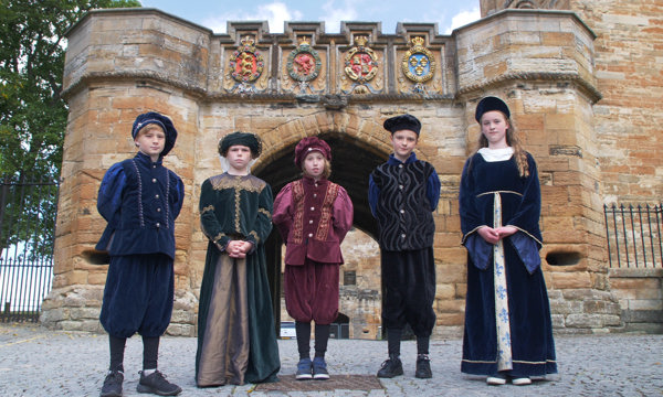 Junior tour guides in costume standing outside Linlithgow Palace
