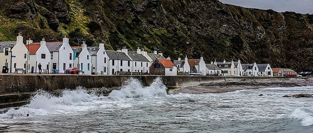 View of the single row of whitewashed buildings in the small village of Pennan in Aberdeenshire