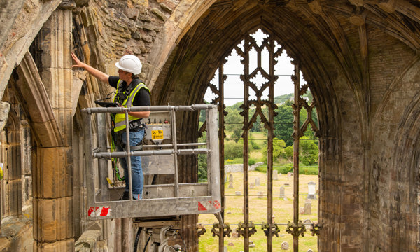 Member of our conservation team in a chery picker at Melrose Abbey doing hilgh level inspections
