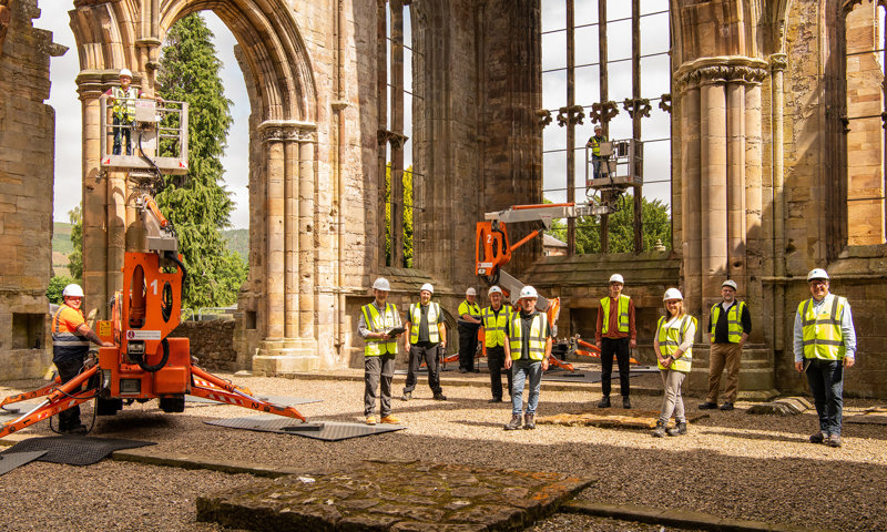 Conservation staff in hard hats and high visibility jackets working on high level inspections at Melrose Abbey