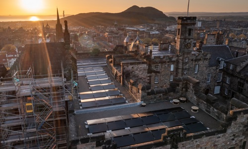 Landscape photo of the solar panels on the roof of the Scottish National War Memorial Building, Edinburgh Castle in the sunset.