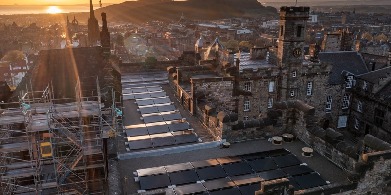 Landscape photo of the solar panels on the roof of the Scottish National War Memorial Building, Edinburgh Castle in the sunset.