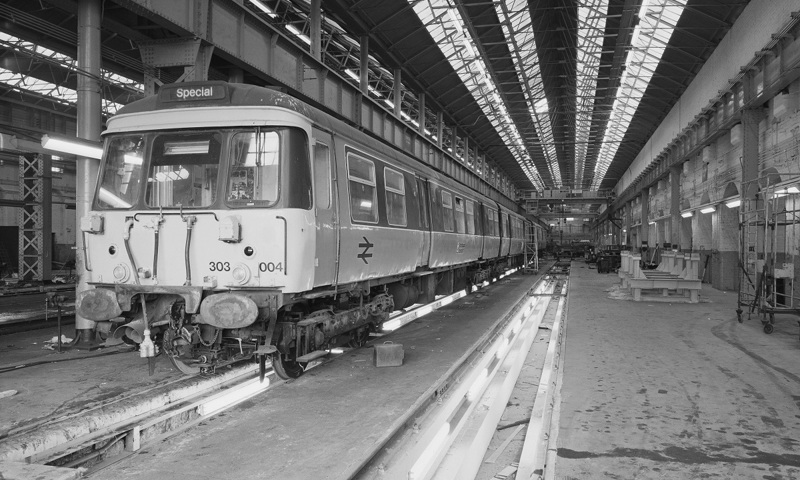An archive photo of a train carriage being repaired inside a large workshop at a locomotive works 
