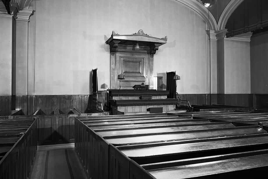 A modest, wooden church alter and wooden pews looking onto it.  Image reference number: SC_981930