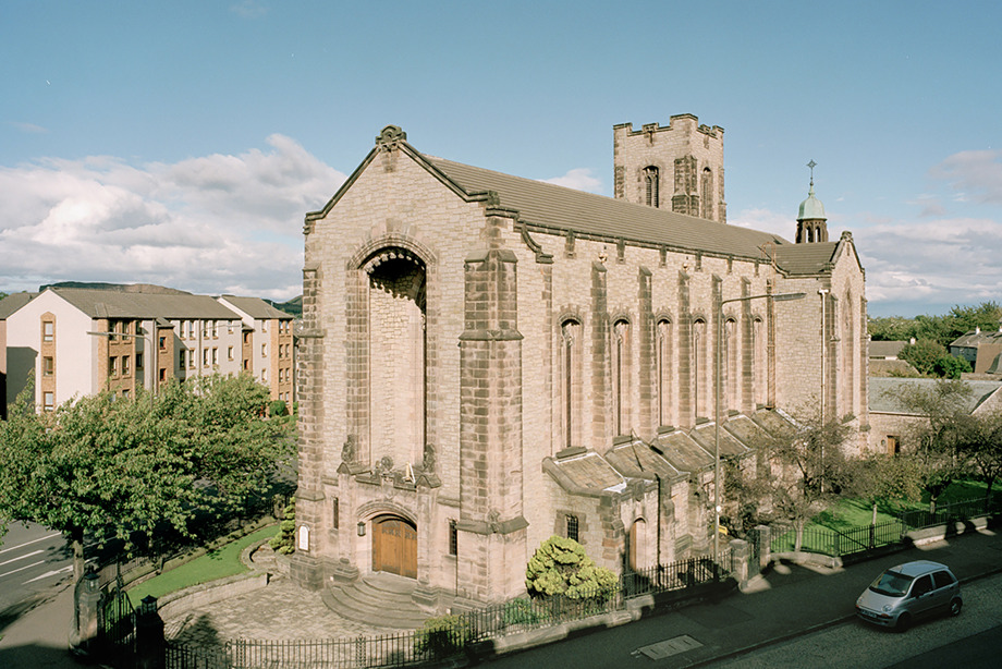 A tall, long historic stone church surrounded by greenery. Image reference number: SC_982771