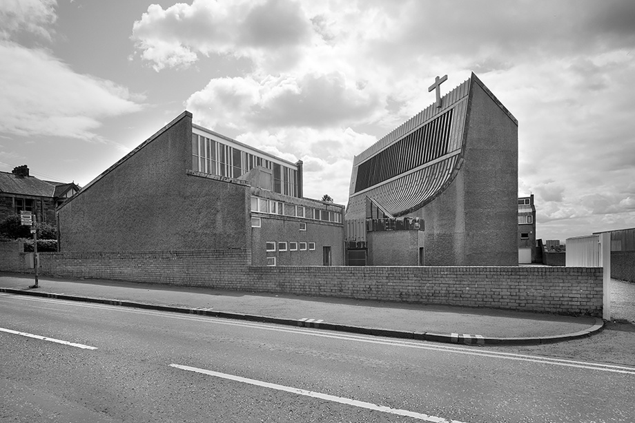 A brutalist / modern looking church with blocky features but one deeply curved wall. Image reference number: SC_1062367