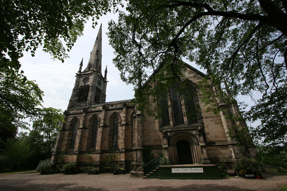 A large stone church with decoratively carved stonework and a large spire
