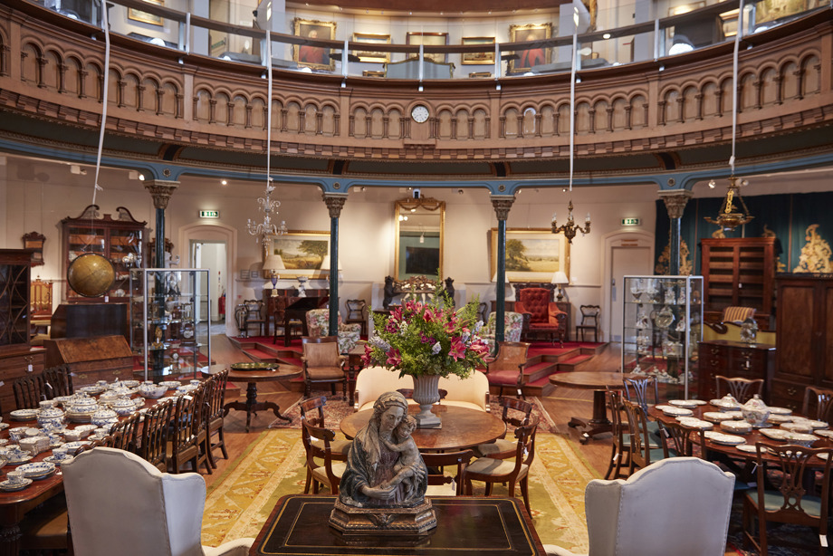 Tables and chairs set up in a central space surrounded by a balcony
