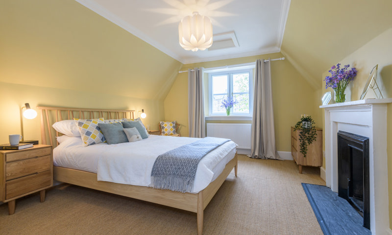 Double bedroom in Meadowbank Lodge, nice and bright with pale yellow walls and flowers 