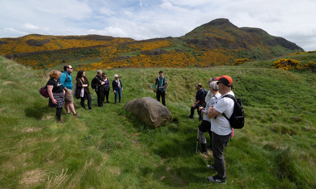 A group of people walking through Holyrood Park