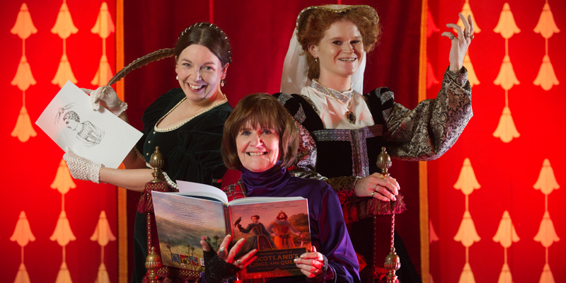 Two costumed performers in medieval dresses pose alongside an author