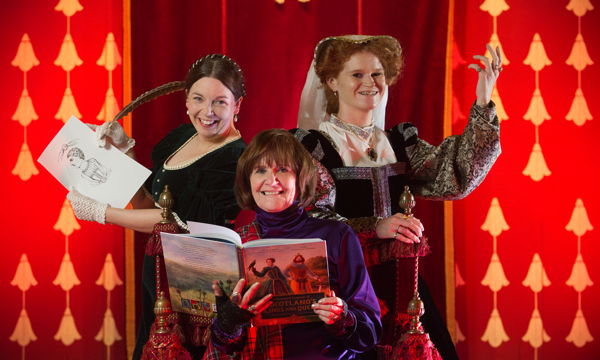 Two costumed performers in medieval dresses pose alongside an author