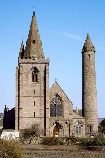 A large stone cathedral with a spire and slate-roofed round tower