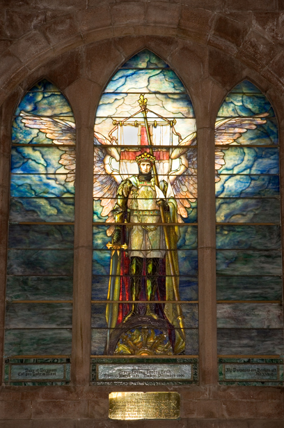 A stained glass window of a winged angel wearing armor