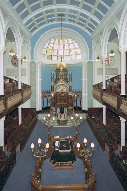 The inside of a synagogue with a carved wooden balcony and wooden pews. Reference no: SC_924502