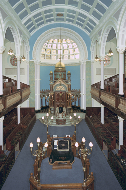 The inside of a synagogue with a carved wooden balcony and wooden pews. Reference no: SC_924502