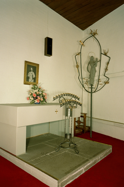 A rectangular alter with a stone floor, staged with candles, flowers and a picture on the wall. Reference no: SC_713596