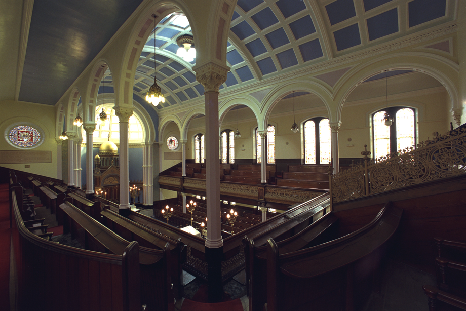 A space with a tall, curved ceiling and dark, wooden balconies and benches. Reference no: 000-000-034-259-R