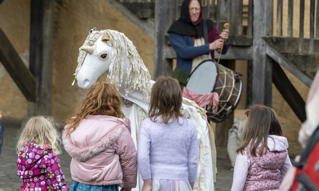 Story time with unicorn puppet at Stirling Castle, with small children watching in the foreground. 
