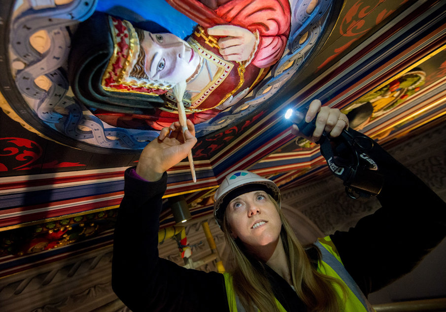 Regional Collections Manager, Lynsey Haworth, cleaning one of the Stirling Heads in the Kings Presence Chamber at Stirling Castle