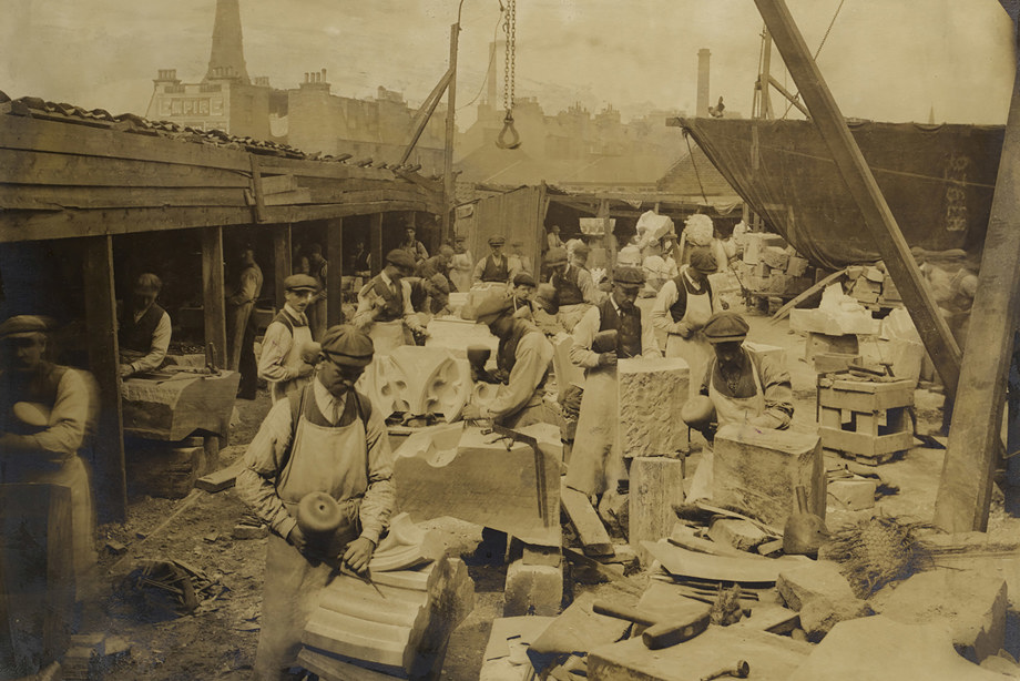 Many people, wearing hats and aprons, carving blocks of stone with chisels. Reference no: DP_312883 