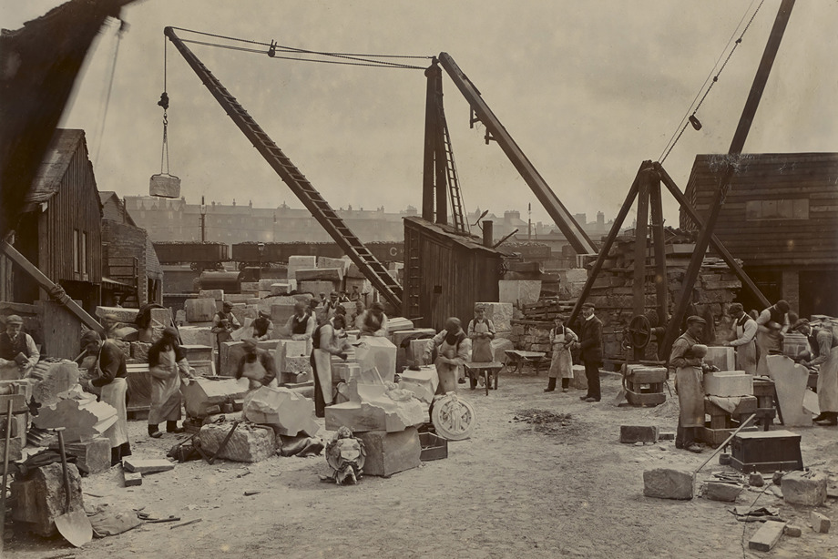 Many stonemasons, carving blocks of stone with chisels, in an outdoor workshop. Reference no: DP_312890 