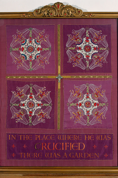 A framed cloth with floral embroidery and "in the place where he was crucified, there was a garden" stitched into it. Reference no: SC_1145388