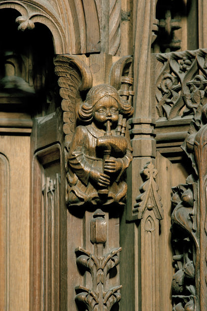 A wood-carved wall featuring an angel playing the bagpipes. Reference no: SC_752526 