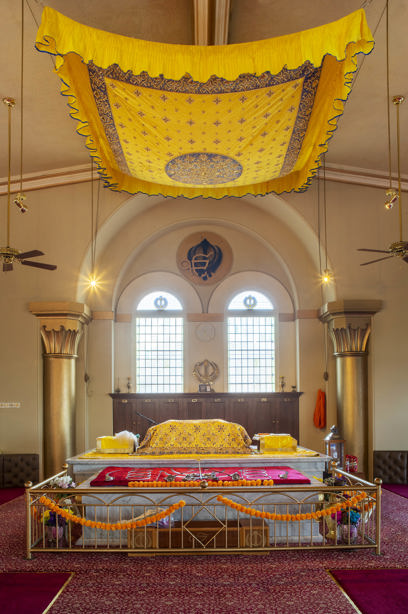 A yellow canopy hanging from the ceiling, over a colourful structure for worship. Reference no: DP_374205