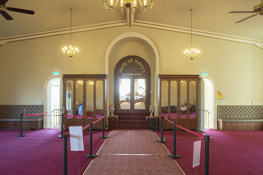 A carpeted room, leading towards a set of steps into another room. Reference no: DP_374185