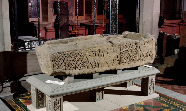A large, carved stone on it's side, on top of a display table 008-001-043-421-R 