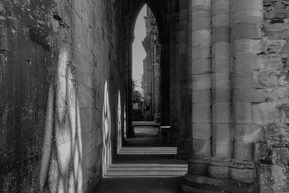 A long, narrow corridor with a carved, arched ceiling and columns