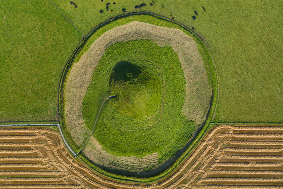 A grassy mound in the middle of a field