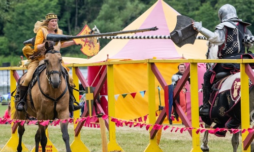 A woman in Renaissance clothing jousts with a knight